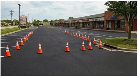 Parking lot after sealcoating and striping — fresh black surface