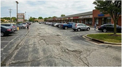 Parking lot before sealcoating — cracked and faded