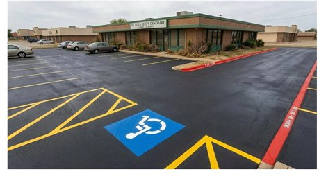 Dentist office parking lot after — fresh sealcoat, new ADA markings, yellow striping, red fire lane