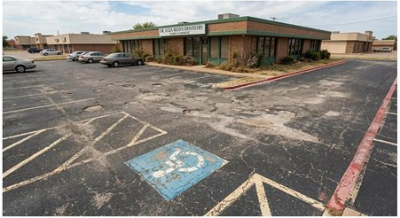 Dentist office parking lot before — faded ADA markings, cracked and worn asphalt